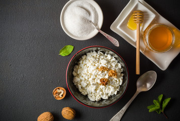Fresh white cottage cheese in a bowl on the table. Tasty and healthy breakfast. dark stone surface. View from above. A lot of space for text.