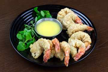 shrimp in batter with sauce and salad in a plate