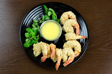 shrimp in batter with sauce and salad in a plate