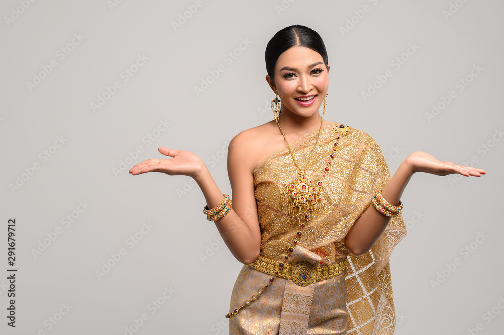 Wall mural women wear thai clothes and open their hands on both sides.