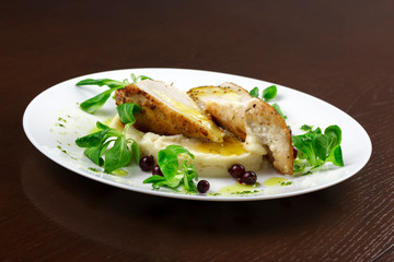 mashed potatoes with chicken breast and herbs in a sauce with berries