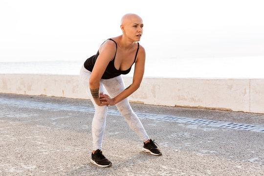 Image of caucasian bald woman doing exercises while working out