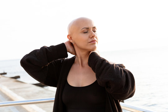 Image Of Calm Bald Woman Stretching Neck While Working Out