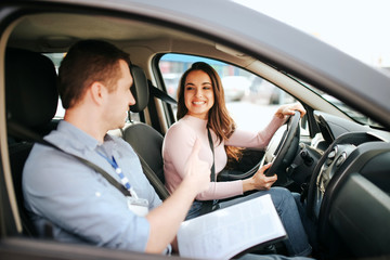 Male auto instructor takes exam in young woman. Practical issue. Cheerful happy and positive...