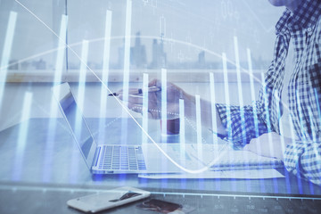 Double exposure of stock market chart with man working on computer on background. Concept of financial analysis.