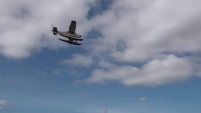 Tracking shot of seaplane flying overhead and coming in for landing