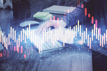 Stock graph with businessman typing on computer in office on background. Concept of analysis. Double exposure.