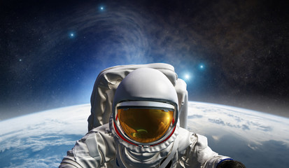 Astronaut at spacewalk. Concept of conquering the universe by the human race. Elements of this image furnished by NASA