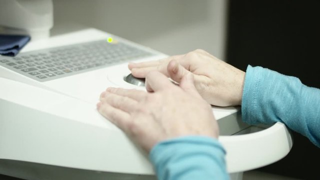 Close up of hands using digital crown design device in dental office