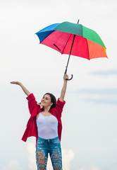 Pretty woman with colorful umbrella. Rainbow umbrella. Rainy weather. Good mood. Good vibes. Open minded person. Girl feeling good sky background. Easy and free. Good weather. Welcoming fall