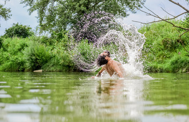 Fototapeta na wymiar Freshness of wild nature. Summer vacation. Deep dangerous water. Splashes of freedom. Relaxation and rest. Swimming sport. Swimming skills. Man enjoy swimming in river or lake. Submerge into water