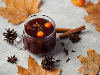 Naklejka na ściany i meble Hot fruit tea or mulled wine with blueberries, kumquat and spices in a glass mug