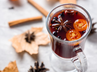 Hot fruit tea or mulled wine with blueberries, kumquat and spices in a glass mug