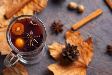 berry fruit mulled wine with kumquat, blueberries and spices in a glass on a brown table