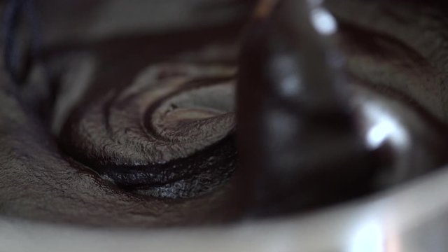 Stirring rich melted chocolate couverture close up