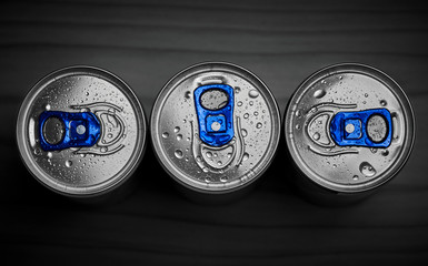 Three energy drinks on dark background , top view.