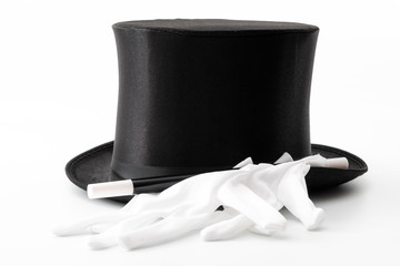 Magic show props, live entertainment and artistic performance conceptual idea with black top hat, white magician gloves and magic wand or baton isolated on white background