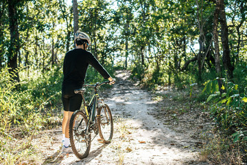 Naklejka premium Male mountain bike standing on the road outdoors in summer nature.