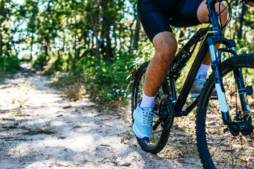 Naklejka premium A low perspective of mountain cyclists on a rocky path at sunset Focus on shoes
