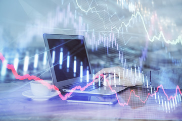 Double exposure of man's hands writing notes of stock market with forex graph background. Concept of research and trading.