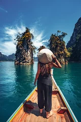Foto op Canvas young woman tourist in asian hat on the boat at lake © zolotareva_elina
