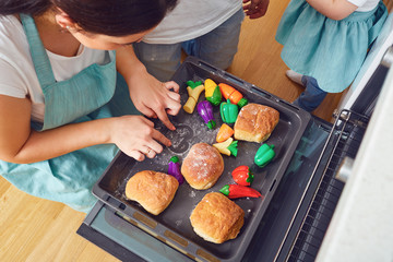 Mother playing teaches children to cook.