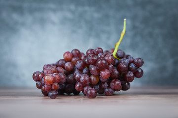 Red grape on wooden table - Bunch of grapes juicy fruit on light and dark background
