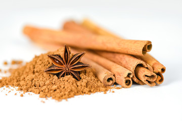 Cinnamon sticks and Star Anise on cinnamon powder herbs and spices on white