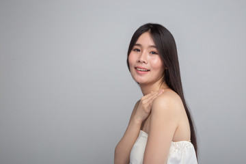 Obraz premium The woman wore a white strapless dress and hands rested on her shoulders.