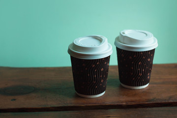 A cup of coffee on wooden background. Beautiful foam, pink ceramic mug, stylish toning, copy space.