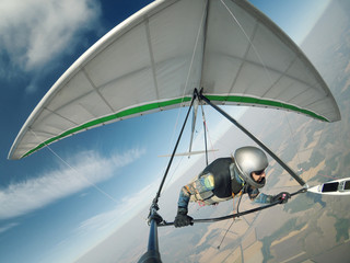 Hang glider pilot flies on high altitude.