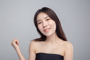 The woman wore a black strapless and raised her right hand.