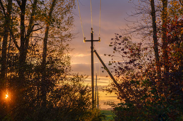 Obraz premium Power line on the background of beautiful dramatic sunset . Electrical wires on poles