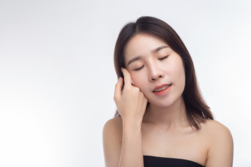 The woman wore a black strapless dress and hands touch her face.