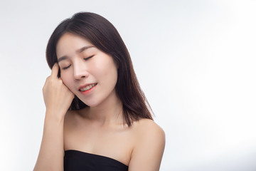 Fototapeta premium The woman wore a black strapless dress and hands touch her face.