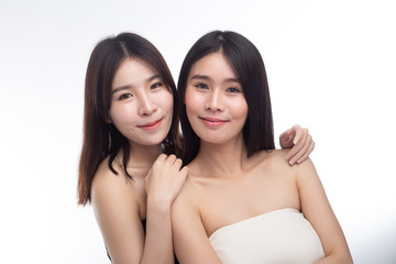 Two young women happily stood together from behind.