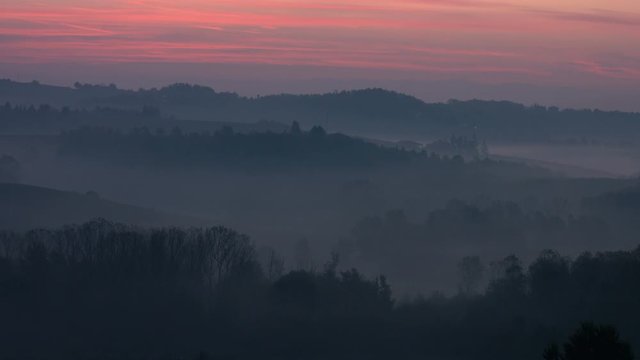 Magic evening dawn over hills covered by fog in fall