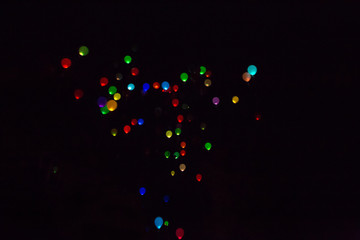 Colorful, glowing Balloons Flying in the Dark Night Sky.