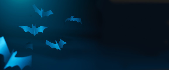 Halloween photo of blue paper bats on blank dark blue background.