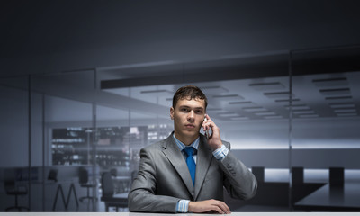 Young man talking on phone and looking at camera