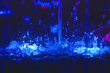 splashing water in a fountain with multi-colored light