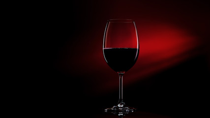 Glass of red wine on black to red gradient background. Concept studio shot.