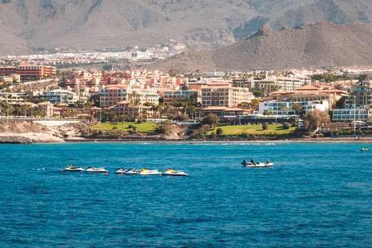 group of jet ski in ocean with hotels at coust in background  -