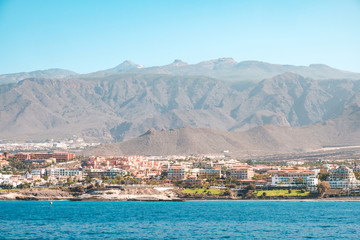 city with hotel buildings at coast with mountain landscape background - ocean view on Tenerife Island