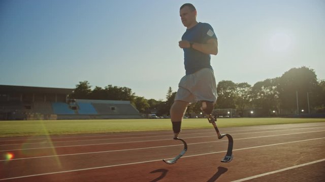 Athletic Disabled Fit Man with Prosthetic Running Blades is Training on a Outdoors Stadium on a Sunny Afternoon