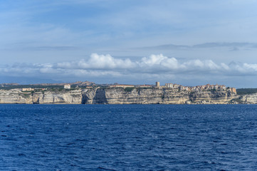 Panoramic view from the sea to the white limestone cliffs and the city of Bonifacio Corsica of the sea and blue sky