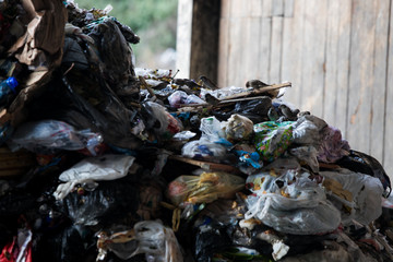 Truck tipping garbage from container on junk yard