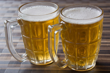 Two Mugs of Chilled Beer on a Table