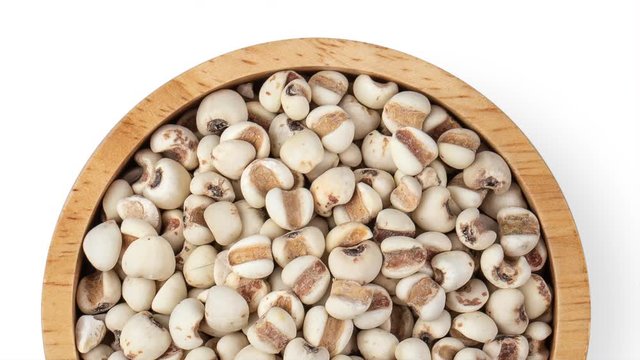 panning Job's tears in wood bowl isolated on white background. top view