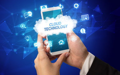 Female hand holding smartphone with CLOUD TECHNOLOGY inscription, cloud technology concept